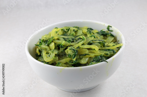 Stir fried spinach and onion. Concept of vegan food or garnish at least. White background.