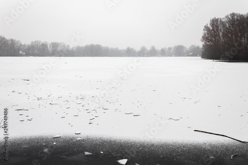 completely frozen lake surface covered in snow snowy cloudy winter photo