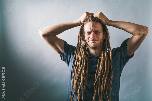 Canvas-taulu Young man feeling stressed out on a solid background