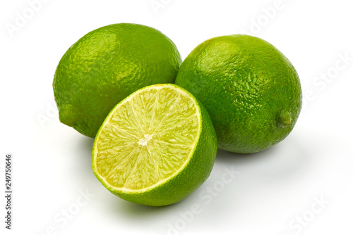 Fresh Ripe Limes with juicy half, close-up, isolated on white background