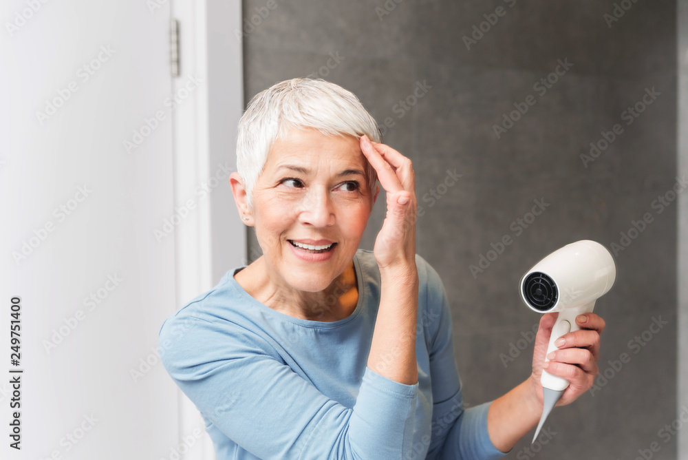 Woman drying her hair at home