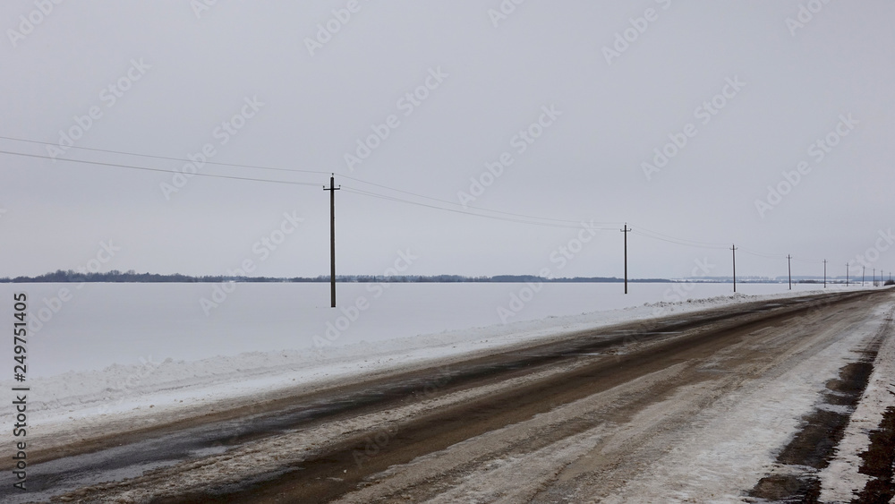 Sad landscape with a deserted winter road in the steppe, Russia