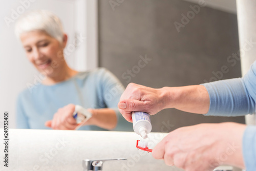 Woman putting toothpaste on a brush