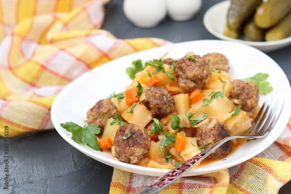 Stewed potatoes with meatballs on a white plate Stewed potatoes with meatballs on a white plate