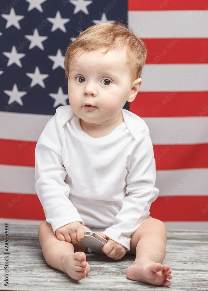 Naklejka premium Child with a phone on the American flag background