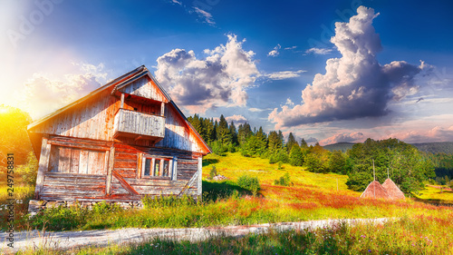 Beautiful countryside landscape with forested hills and haystacks on a grassy rural field in mountains photo