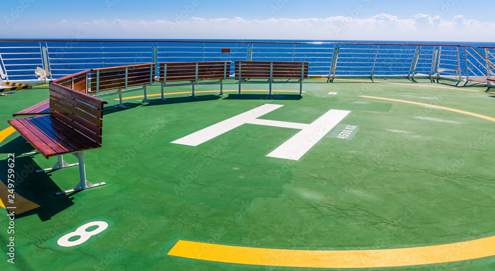 Fototapeta premium Benches on the green helicopter ship on the bow of a cruise ship