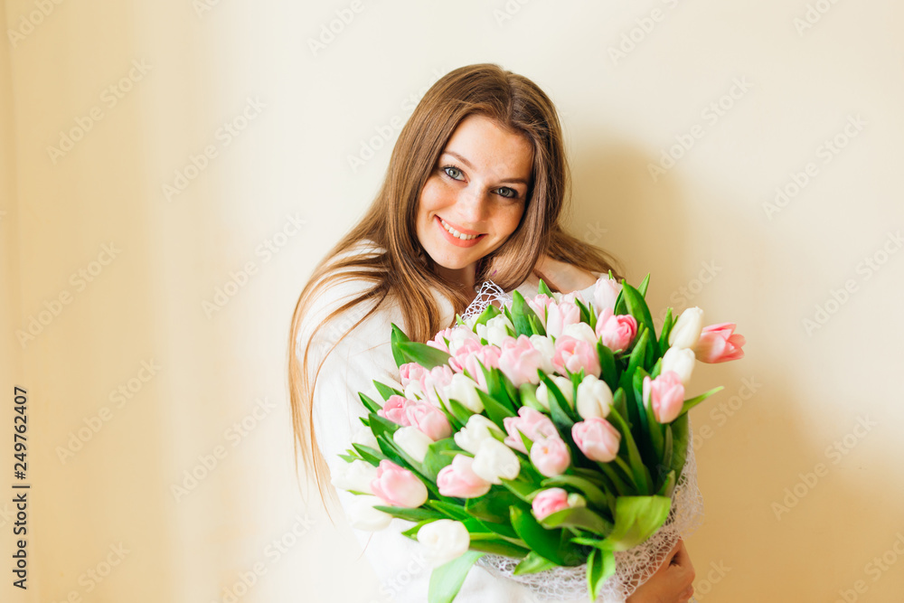 Attractive girl with big bouquet of white and pink tulips. Attractive girl with big bouquet of white and pink tulips.