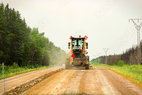 Traveling on a gravel road behind a grader