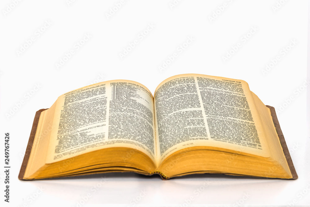 Open bible on plain white background with yellowed pages Open bible on plain white background with yellowed pages