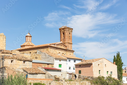 old rustic houses and the Santa Cruz parish church in Plou town, province of Teruel, Aragon, Spain photo