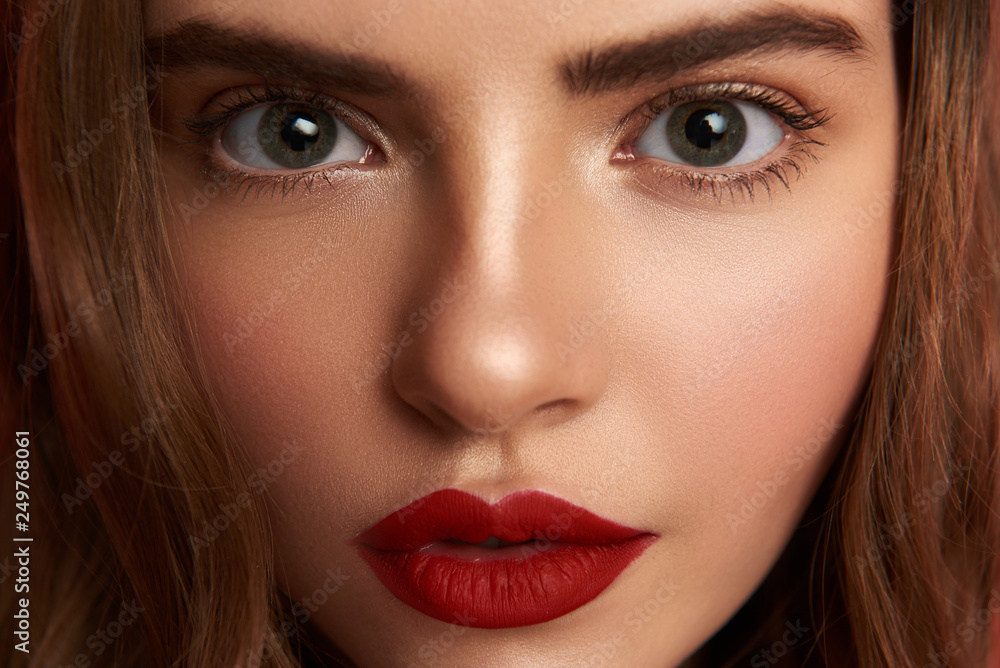 Cropped photo of pretty young woman with red lips looking at camera Cropped photo of pretty young woman with red lips looking at camera