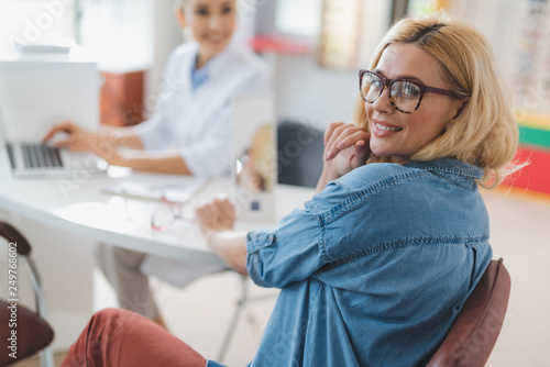 Konstfotografi Cheerful blonde woman visiting an optical store