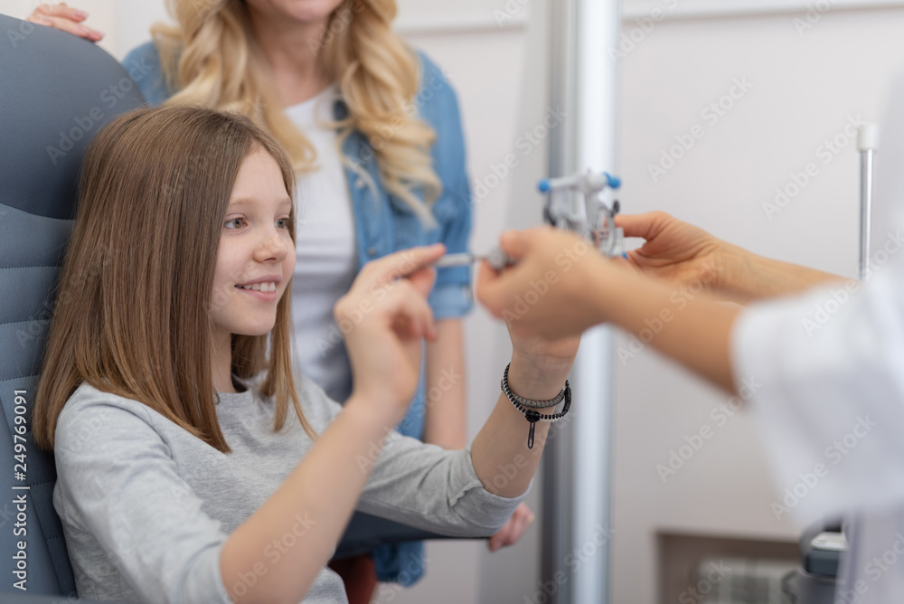 Ophthalmologist giving optical trial frame to smiling little girl Ophthalmologist giving optical trial frame to smiling little girl