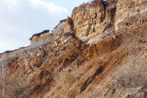 Landslide zone on Black Sea coast. Rock of sea rock shell. Zone of natural disasters during rainy season. Large masses of earth slip along slope of hill, destroy houses. Landslide - threat to life