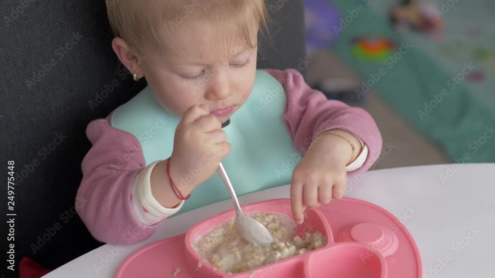The little girl to learn to eat with a spoon The little girl to learn to eat with a spoon