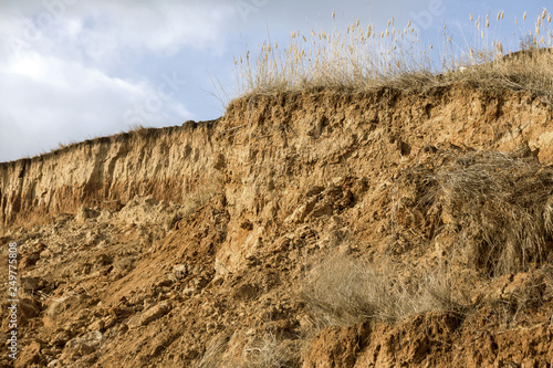 Landslide zone on Black Sea coast. Rock of sea rock shell. Zone of natural disasters during rainy season. Large masses of earth slip along slope of hill  destroy houses. Landslide - threat to life