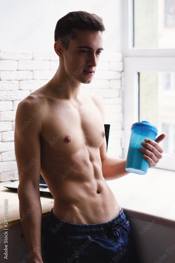 sport, healthy food, fitness, proper balanced nutrition, diet supplement,  bodybuilding, motivation. young fit sporty man with muscle body drinking  protein shake at home kitchen Stock Photo | Adobe Stock