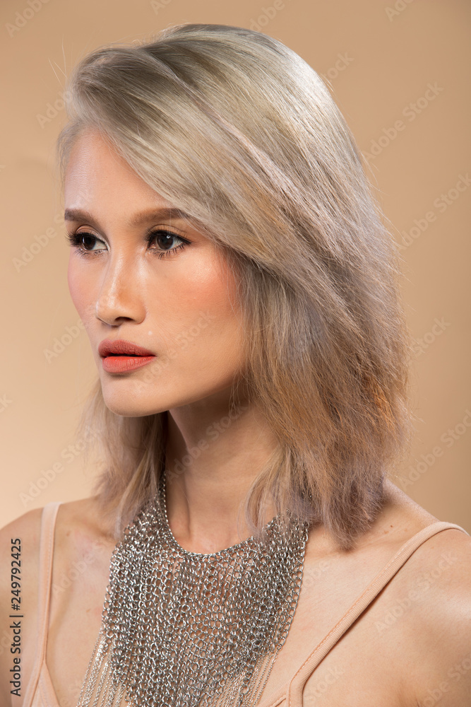 Asian Woman after applying make up silver gray hair style. no retouch,  fresh face with lips, eyes, cheek, nice smooth skin. Studio lighting beige  yellow background, for aesthetics therapy treatment Photos