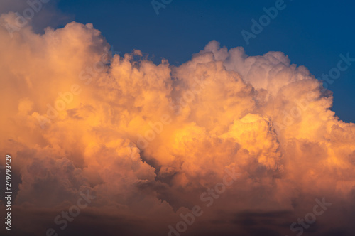 Blue sky and white fluffy clouds on sunset sky. White cumulus clouds. Dramatic sky and clouds abstract background. Warm weather background. Art picture of clouds at dusk. Cloudy sky. © Artinun