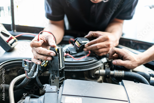 People or mechanic car repair during investigate cause of problem (electric system check) or working on automobile gasoline or diesel engine at garage