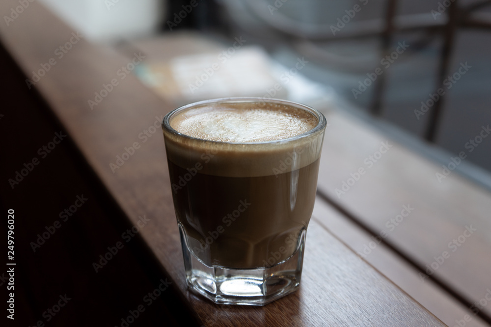 Cortado Coffee in Glass on Wooden Bar Cortado Coffee in Glass on Wooden Bar