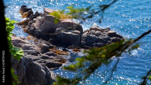 Gushing the sea. Waves crashing against stones sticking out of troubled water. photo