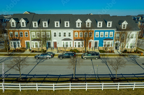 Typical American town house, town home neighborhood with colorful real estate houses at a new construction East Coast Maryland location from the air with blue sky