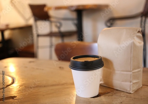 Coffee cup and bag of coffee beans in coffee shop