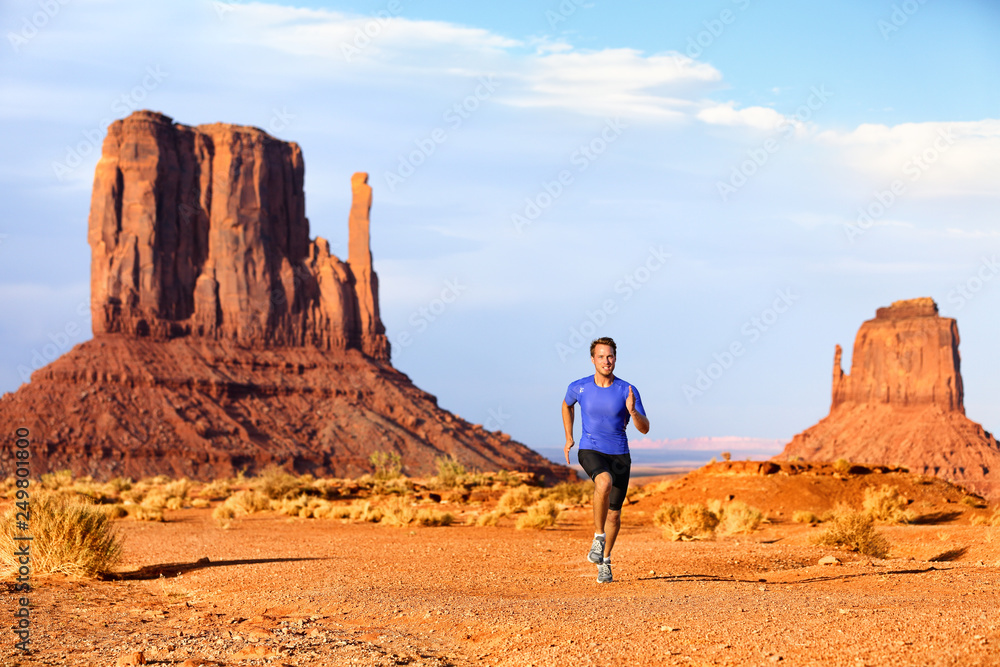 Trail running runner athlete doing race goal challenge. Fitness man sprinting across desert in Monument Valley, cross country marathon endurance training in Arizona, Utah, USA. American travel. Trail running runner athlete doing race goal challenge. Fitness man sprinting across desert in Monument Valley, cross country marathon endurance training in Arizona, Utah, USA. American travel.