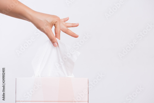 Healthcare concept. Woman hand picking white tissue paper from tissue box. photo