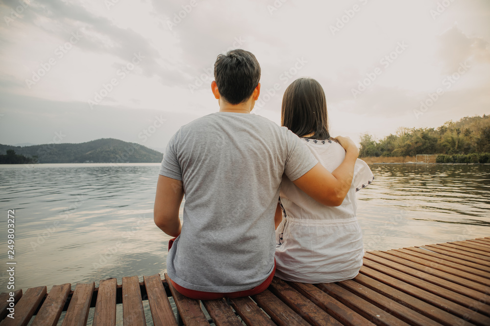 Lover couple hold together and admire the romantic beautiful lake landscape.