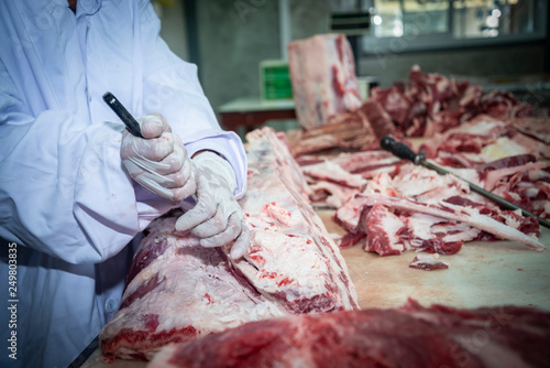 The butcher runs the butcher's knife to cut the beef. In Thai slaughterhouse in Sakon Nakhon province