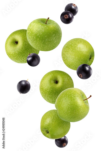 Falling (flying) green apples and black currant isolated on white.
