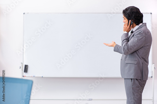 Young handsome businessman standing in front of whiteboard 