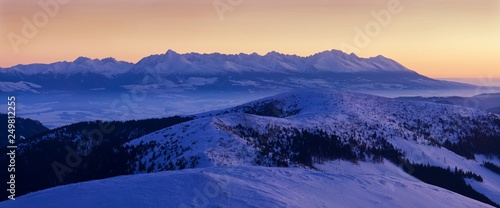 Mountain landscape panoramic view with blue sky Gorgeous winter sunset in Carpathian mountains. Colorful outdoor scene  Happy New Year celebration concept. Panorama of white winter mountains with snow