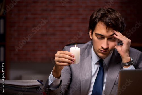 Businessman working late in office with candle light