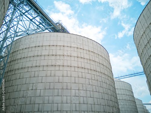 grain silos, grain elevator and Conveyor Belt with blue sky as the background, An idea of agricultural products keeping.