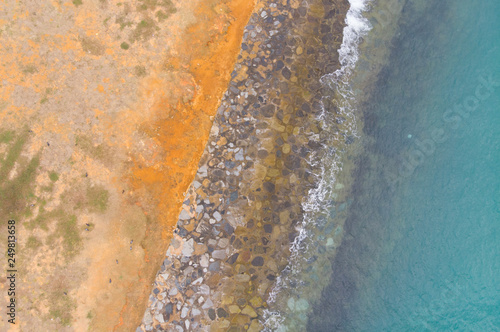 Vertical view ( aerial photo) of waves breaking gently on a breakwater 