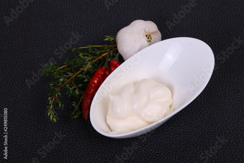 Mayonnaise sauce in the white bowl served thyme and garlic