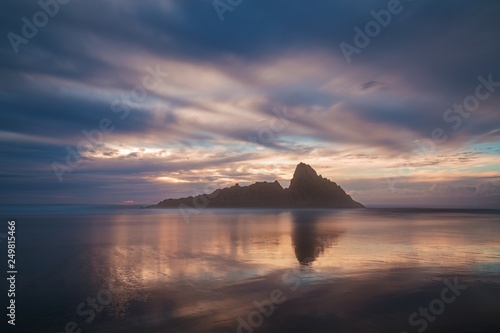 Sunset on the coast of the New Zealand at dawn with rocks in background. Beautiful romantic seascape