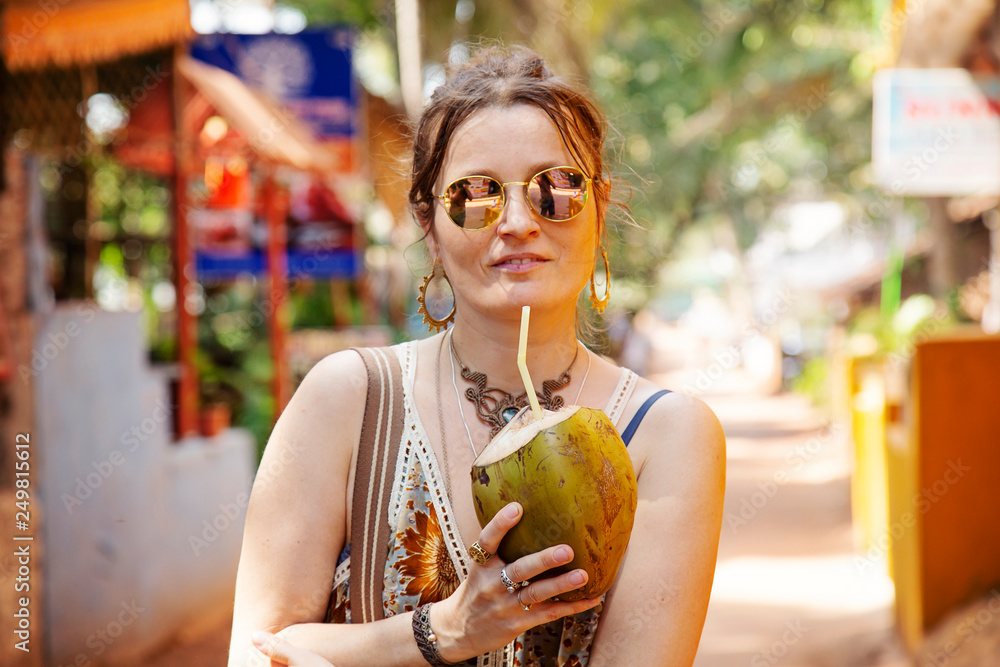 Woman on the street with young coconut drink - obrazy, fototapety, plakaty 