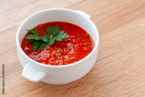 Tomato-lentil soup, decorated with herbs. Ingredients: tomatoes in their own juice, lentils, onions, spices.