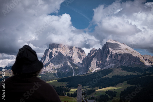The silhouette of an elderly woman looks in the evening light in the mountains, thinking about earlier times. Seiser Alm