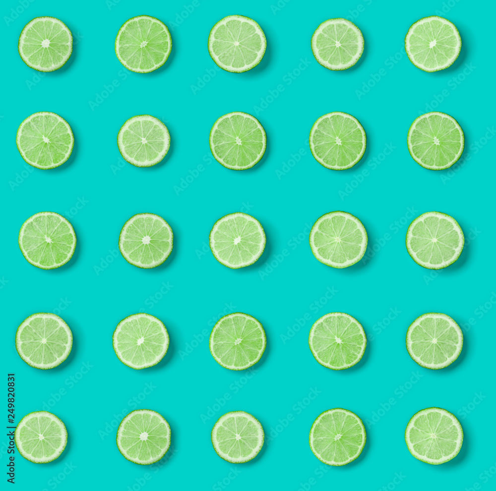 Fruit pattern of lime slices on blue background. Flat lay, top view. .  Pop art design, creative summer concept.