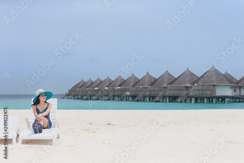 A woman sitting on the chair on the beach
