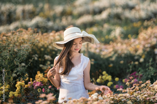 girl in hat in flower garden
