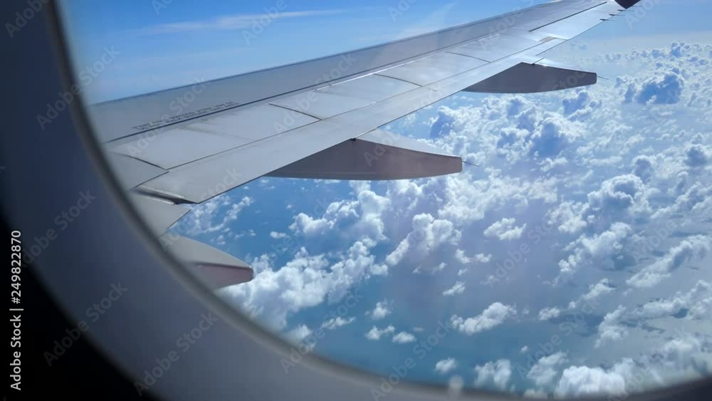 View from the window of the plane wing of an airplane flying above the clouds View from the window of the plane wing of an airplane flying above the clouds