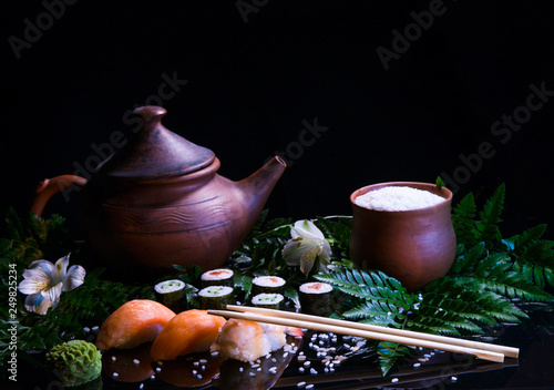 Japanese style sushi composition on a dark backgrong with smoke and green leaves photo