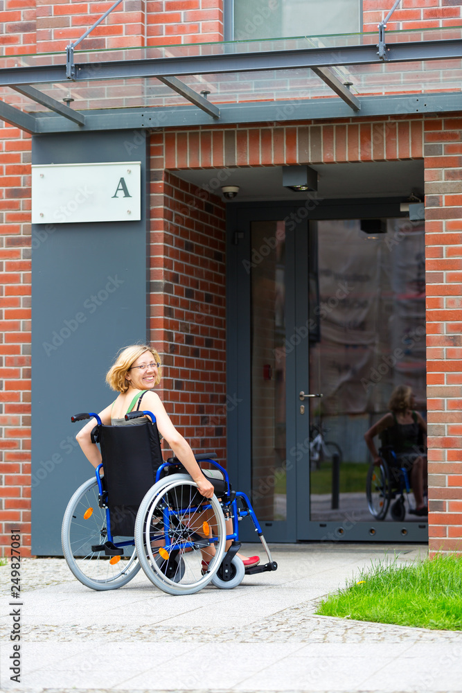 woman on wheelchair entering the building woman on wheelchair entering the building